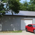 Gray Shed With Red Car Beside